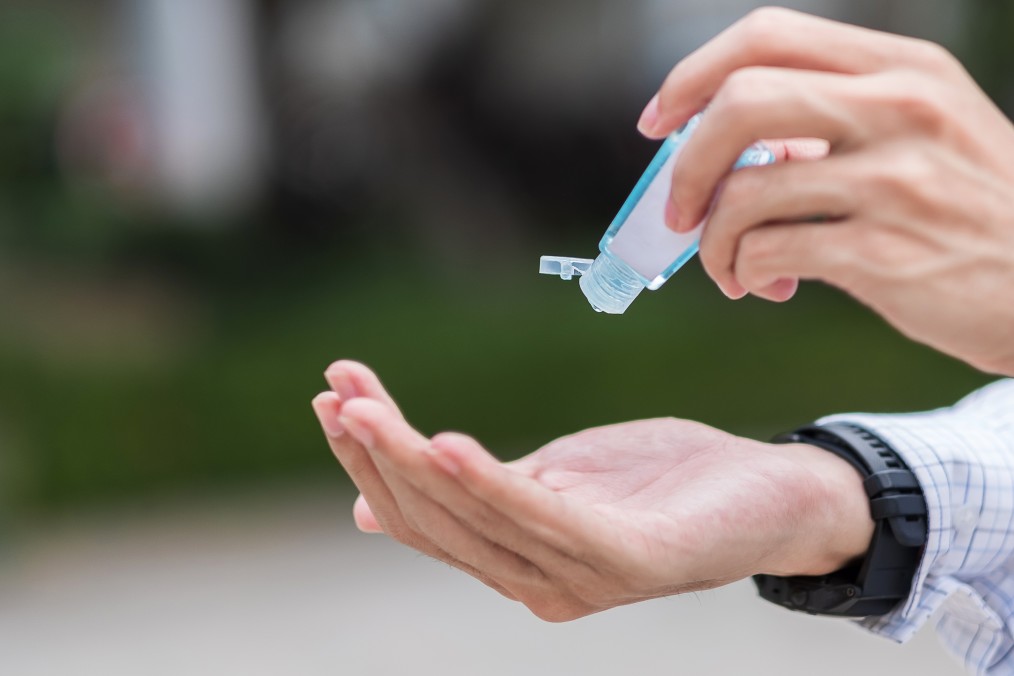 acidente de trabalho - pessoa colocando álcool em gel na mão