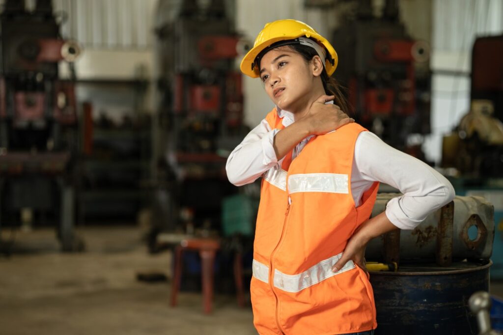 acidente no trabalho - mulher usando colete de trabalho com a mão no pescoço